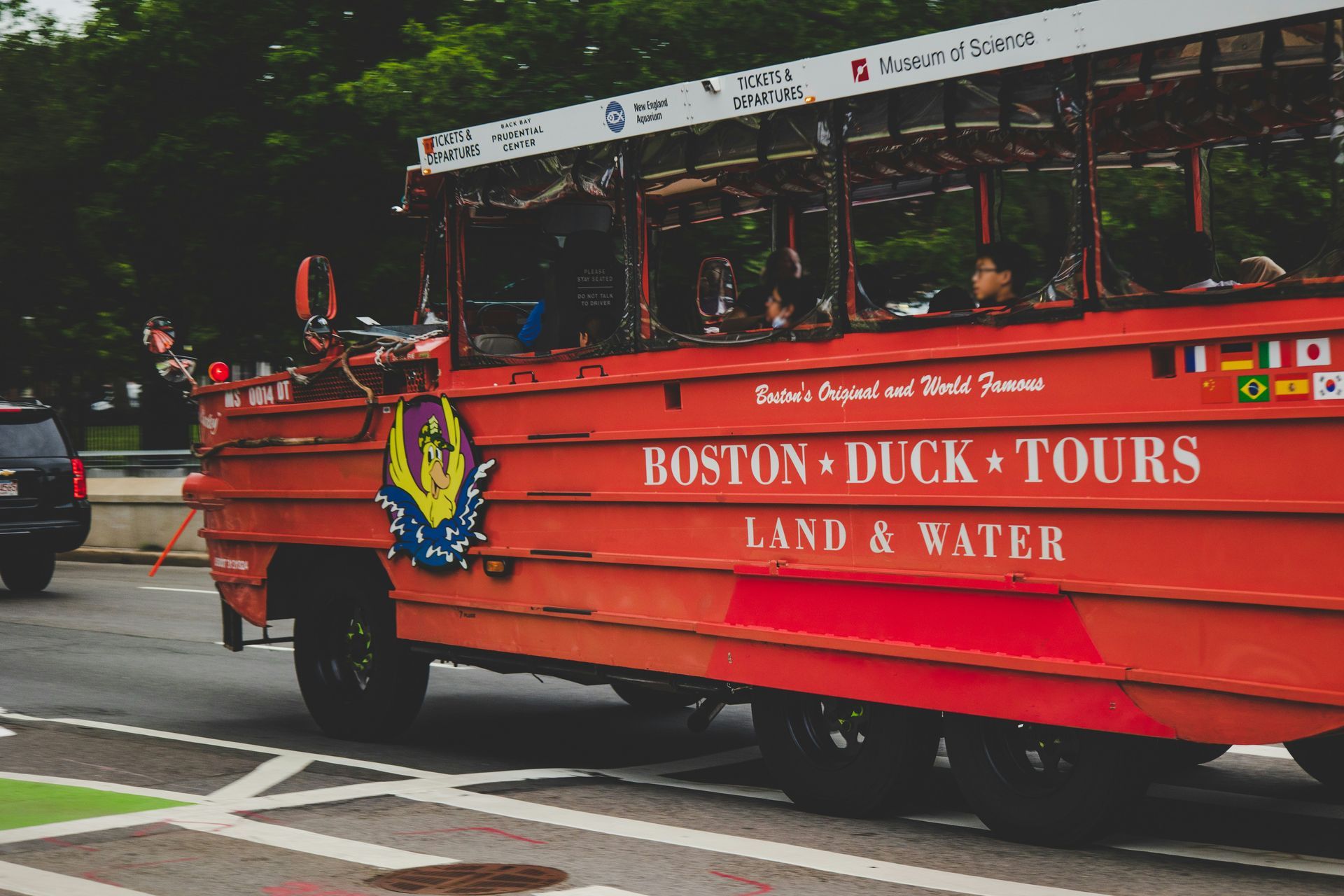 A red Boston Duck Tours bus parked on the side of the road.
